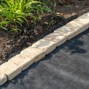 Edging,Of,Laid,Woven,Geotextile,Fabric,With,Sandstone,Pavers,In
